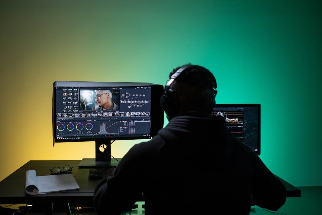 Video editor reviewing footage on a dark workstation monitor, representing secure video review workflows for creative agencies